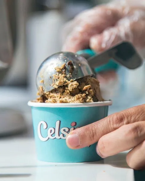A scoop of gelato being pressed into a Celsius cup